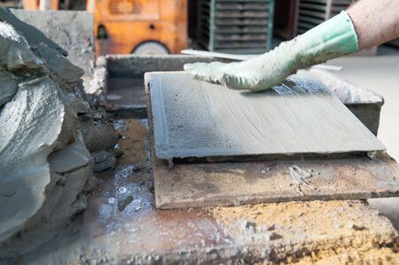 Artisan flattening the clay inside a mould to make square cotto tilesの写真素材