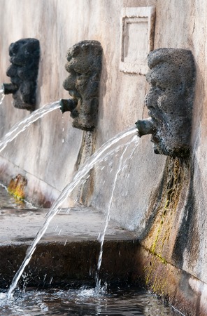 Fountain with lava stone mascarons in one small village at the bottom of Mount Etna, Sicilyの写真素材