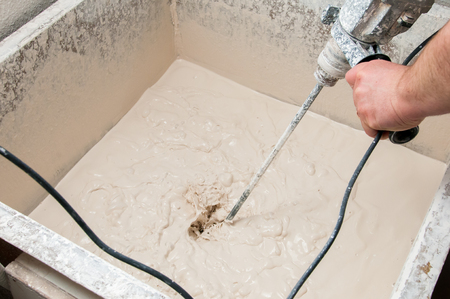 Pottery artisan in Caltagirone, Sicily, mixing the enamel mixture in a big basinの写真素材
