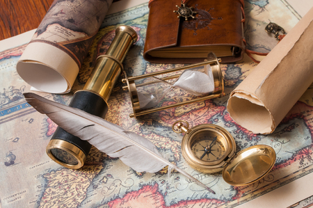 Quill pen and a notebook with old papers, maps and vintage itemsのeditorial素材