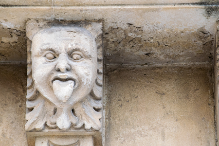 Closeup view of mascarons with a funny face under the balcony of a baroque palace in the province of Syracuse, Sicilyのeditorial素材