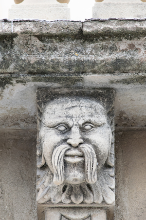 Closeup view of mascarons with  funny faces under the balcony of a baroque palace in the province of Syracuse, Sicilyのeditorial素材