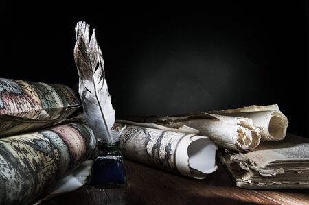 Quill pen, inkwell and old rolled up maps and papers, high contrastの写真素材
