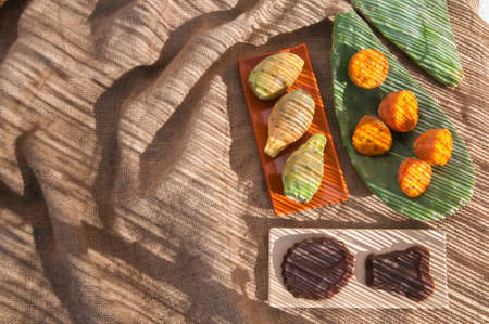 Prickly pears and some mustard shapes on a table with a piece of juteの写真素材