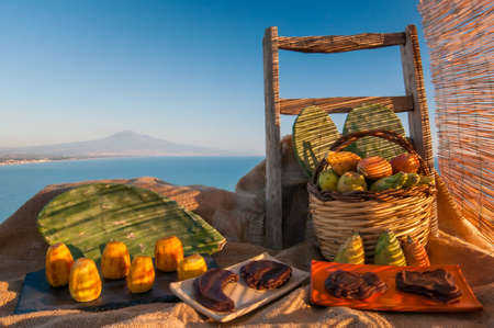 Prickly pears and some mustard shapes on a table with a piece of juteの写真素材