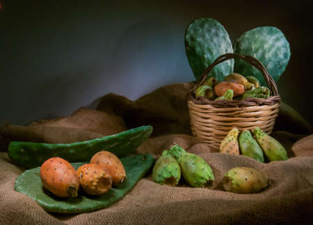 Prickly pears and some mustard shapes on a table with a piece of juteの写真素材