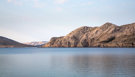 Sea lagoon enclosed by mountains early morningの写真素材