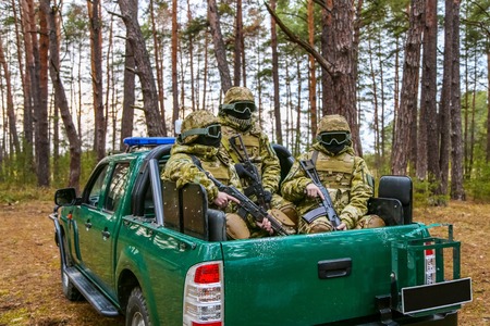 Armed special forces on alert in the body is fighting vehicle on the territory of woods