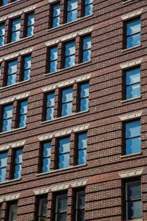 A detail of a skyscraper in New York City, USA. Red brick wall and windows.の写真素材