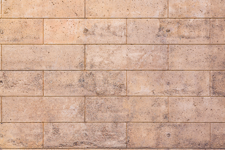 Texture of a stone porous wall, polished with a brick pattern. Background for design.の写真素材