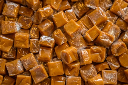 Toffee candy brown background. Caramel cubes close upの写真素材