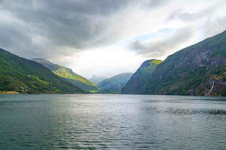 Fjord in Norway - nature and travel background. Beautiful Nature Norway natural landscape. Trip by ship through the fjord. Fjord And Mountain With Snow on the Norway.