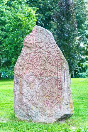 Uppsala, Sweden - July, 2016: Stone with runic inscriptions that are in the university park. Antique Runes on a rock. Runic letters, famous inscription in a stone called.のeditorial素材