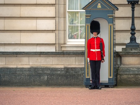 London, UK - April, 2019: A Guard standing outside Buckingham Palace. English guard patrolling in London. Solider of Buckingham palace, London England.のeditorial素材