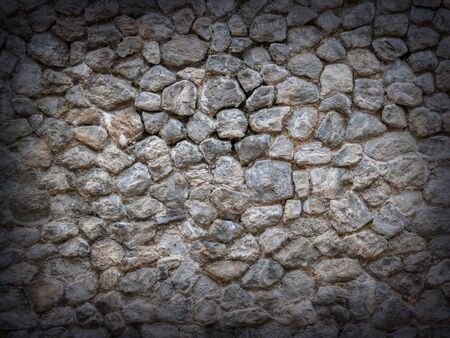 Stone wall background with vignette. Cobble texture wallpaper.の写真素材
