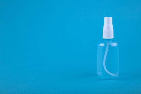 Bottle of antiseptic, a bottle of hand sanitizer, hand sanitizer spray on a blue background, for the prevention of coronavirus, a copy space. Bottle of antiseptic spray mockup, copy space for design.の写真素材