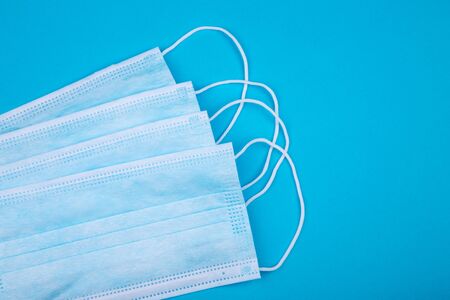 Several medical masks on a blue background, close up, copy space template. Medical mask blue color...