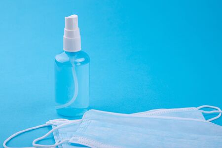 COPY SPACE: Bottle with antiseptic sanitizer and medical mask. Crisis due to coronavirus COVID-19 quarantine. Medical surgical protective face mask with antibacterial antiseptic. Copy space, template.の写真素材