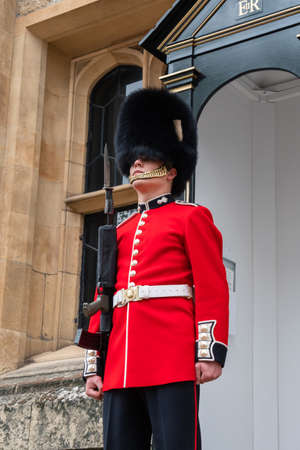 London, UK - April, 2019: English guard soldier. Solider guard of Buckingham palace, London England. Royal guard of London at a post in Buckingham palace, close-up portrait, view from the bottom.のeditorial素材
