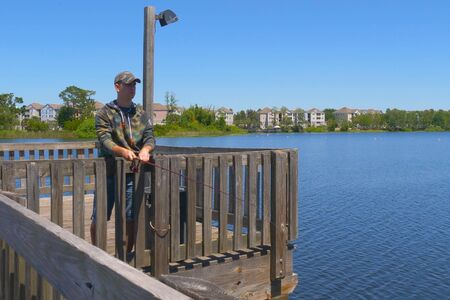 Fisherman cast fishing rod in lake or river waterの写真素材