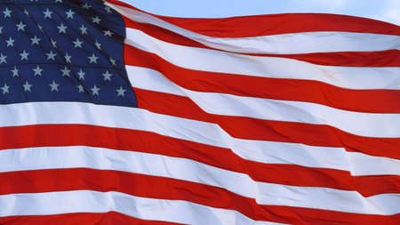 American flag USA Close Up waving background texture. American flag is flying in the wind on a sunny day. Symbol of the Amenrican national holiday. Close-up. Full Frame.の写真素材