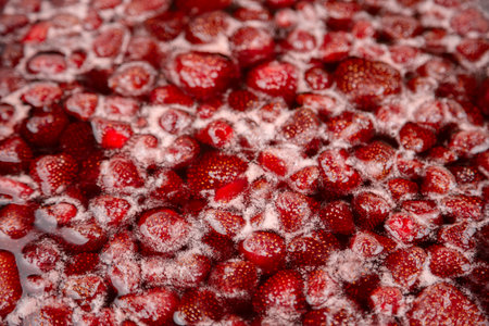 Homemade Strawberry jam in making progress boiling. Process of making homemade strawberry jam. Red sweet syrup boiling on the stove closeup.の写真素材