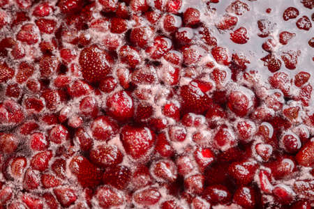 Process of making homemade strawberry jam. Red sweet syrup boiling on the stove closeup. Strawberry jam looks very appetizing. Boiling Homemade Strawberry jam. Cooking strawberry jam close up.の写真素材