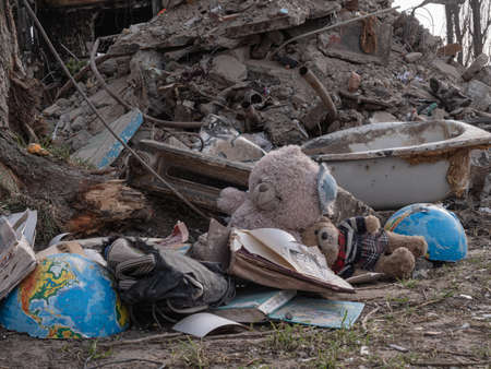 Borodyanka, Ukraine - April 2022: Children's dirty toys near the house after an airstrike by Russian troops. Children died as a result of rocket attacks. Destroyed buildings after the bombing, closeupのeditorial素材