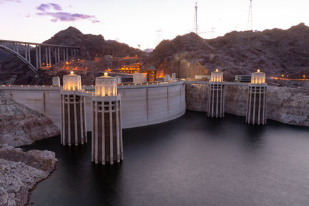 Hoover Dam at sunset in the evening with illuminations without people. Hoover dam, view point. Hoover dam and Lake Mead in Las Vegas area. Large Comstock Intake Towers At Hoover Dam.の写真素材