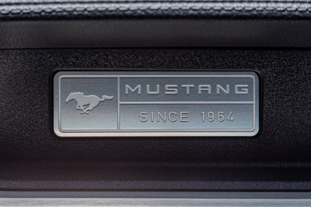 Los Angeles, CA, USA - April, 2017: Signboard, nameplate of American muscle car of legendary Ford Mustang on the dashboard of a car, leather interior, close-up. Ford mustang running horse logo designのeditorial素材