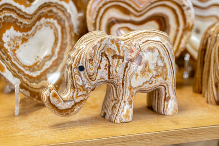 Elephant made of onyx. Elephant statue made of natural onyx stone stands on display case of souvenir shop. Close-up of elephant figure made of onyx. Detailed Close-up reveals mineral patterns of onyx.の写真素材