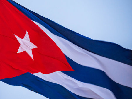 Cuba Flag Waving on flagpole. Cuba flag flaping in wind. Close-up of an Cuban flag flying in the wind against a background of clear sky. Cuba flag Dramatic look, bottom viewの写真素材