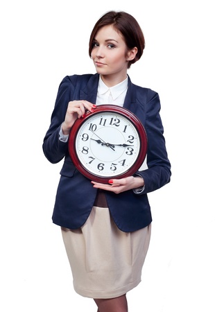 A full length portrait of a beautiful businesswoman with clockの写真素材