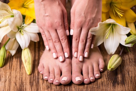 Closeup photo of a female feet at spa salon on pedicure procedure  Female legs in water decoration the flowers の写真素材