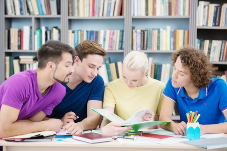Education, campus and teenage concept - Students reading new information in classroomの写真素材