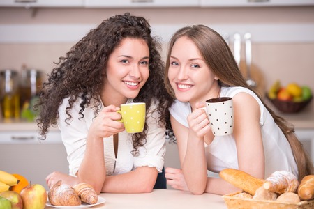 Portrait of a happy women with the morning cups of tea in the kitchenの写真素材