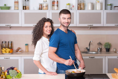 Portrait of a beautiful couple preparing supper together in kitchenの写真素材