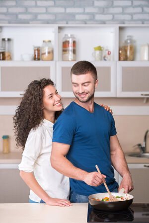 Portrait of a happy couple preparing supper and looking at each otherの写真素材