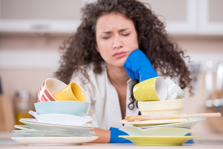 Portrait of a displeased housewife drying dishesの写真素材