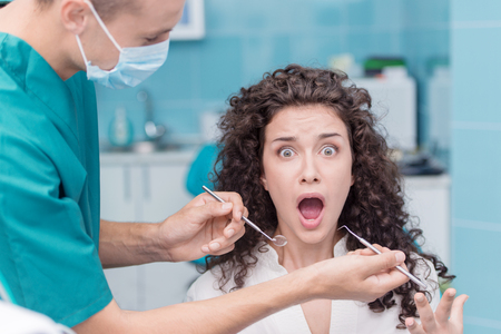 Portrait of a screaming woman at dentist appointmentの写真素材