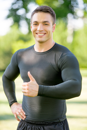 Portrait of a young smiling sportsman with thumb upの写真素材