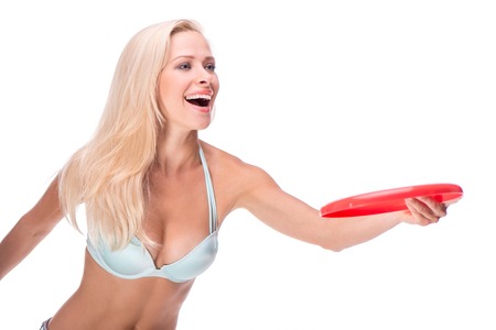 Full isolated studio picture with a young woman in swimsuit with frisbeeの写真素材