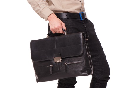 Close-up of young businessman holding black briefcase, isolated on white backgroundの写真素材