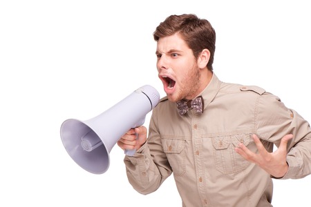 Young handsome angry businessman screaming and holding loud-speaker, isolated on white backgroundの写真素材