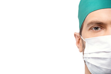 Doctor in the mask looking at camera isolated on white backgroundの写真素材