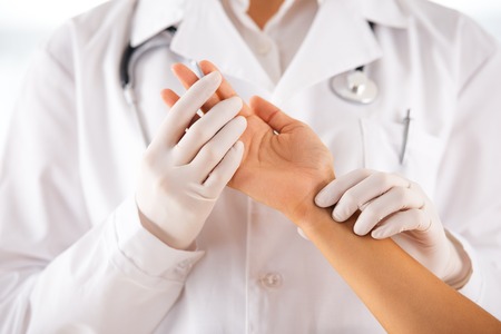 Doctor with stethoscope feeling the pulse og patientの写真素材