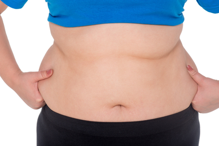 Close-up of fat woman belly, isolated on white. Concept for obesity issueの写真素材