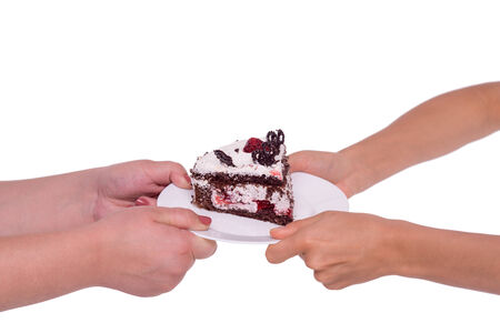 Close-up of woman fight for piece of cake, isolated on whiteの写真素材