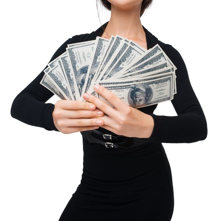 Close-up of young woman holding soft money, isolated on whiteの写真素材
