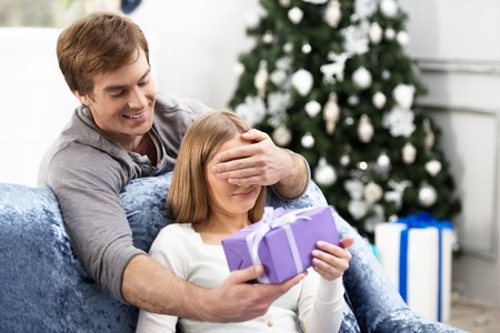 Girl receiving violet Christmas present. Surprise conceptの写真素材